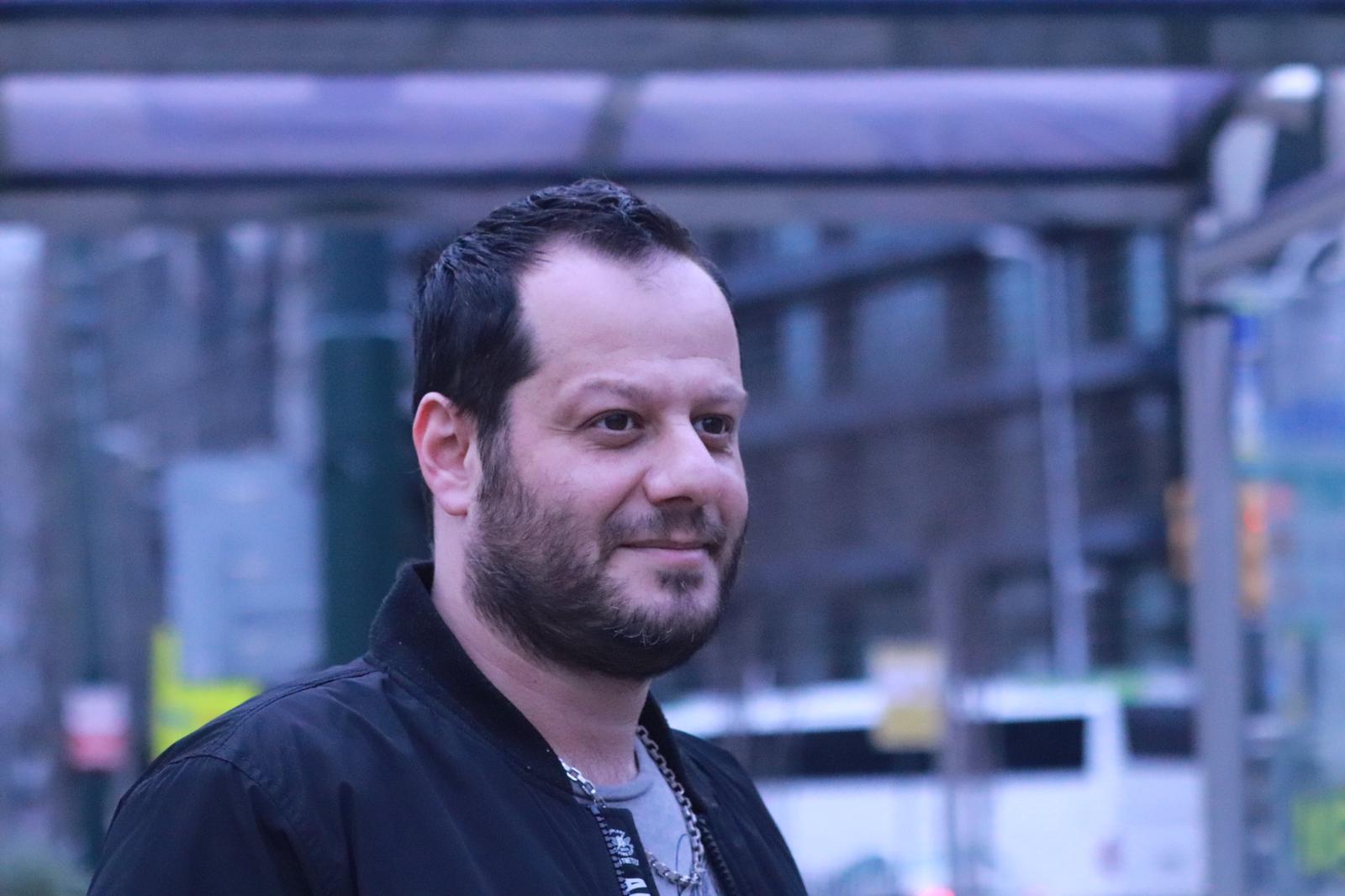 Saeid Hassanzadeh — Iranian writer, poet, and journalist wearing a suit and tie
